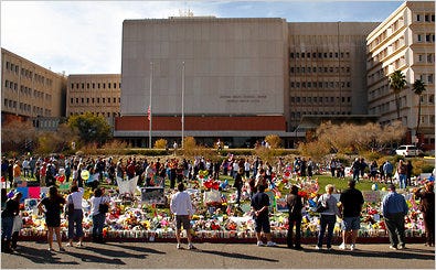 People surrounded a makeshift memorial outside University Medical Center in Tucson, Ariz., on Monday.