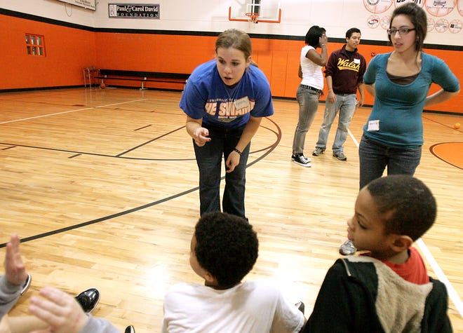 Walsh University students Kendra Gerber and Maria Conti (right) answer questions about college life from the children at the Boys and Girls Club of Massillon. Walsh University students Amber Duckworth and Raymond Davis stand in the background.
