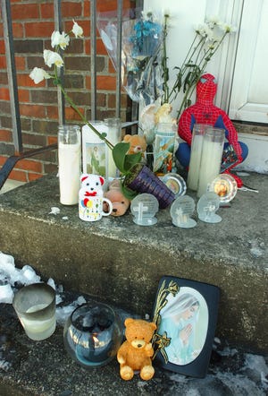 Candles, flowers and a stuffed Spiderman were among items left on steps at 19 Yardarm Lane in Quincy, Monday, January 17, 2011. Brandon Yang, 8, died of monoxide poisoning Thursday, January 13, 2011 and his mother, Li Rong Zhang, was charged with murder.