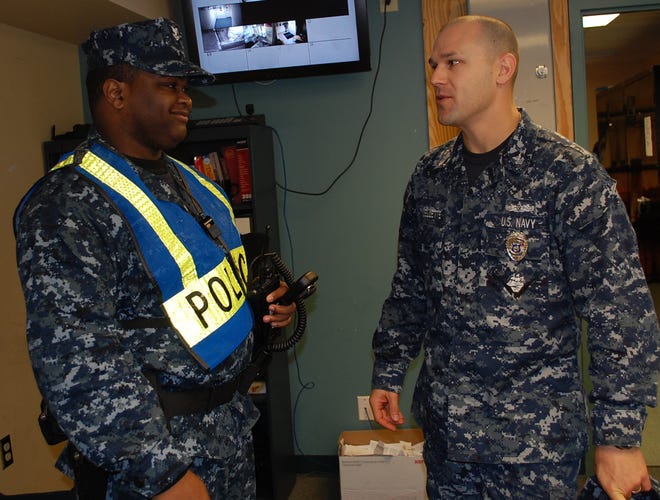 NAS Jax Deputy Security Officer MA1(SW) Nathan Ouellette (right) discusses uniform regulations with HM2(FMF) Wayne Harris of the NAS Jax Auxillary Security Force (ASF) as part of his daily duties of overseeing ASF personnel.