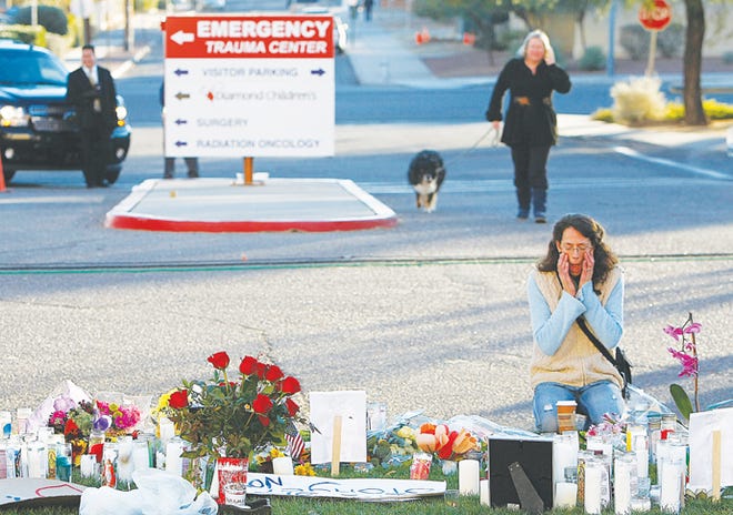 Patty Atkins, right, prays early Sunday morning, Jan. 9, 2011 at a vigil for Rep. Gabrielle Giffords, and other victims at University Medical Center in Tucson, Ariz.MAGS OUT; NO SALES