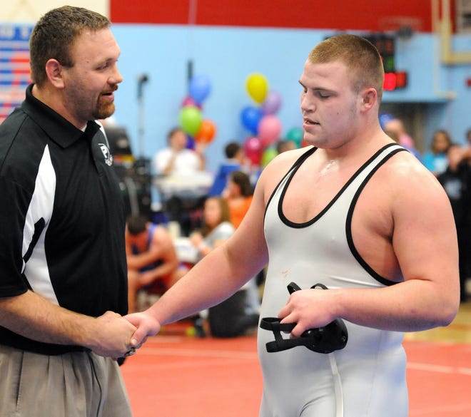 Perry High School wrestler Doug Mayes is congratulated by assistant coach Tim Anderson after last week’s win at Top Gun. Mayes looks to be all the way back from a season-ending injury he suffered at Top Gun a year ago.