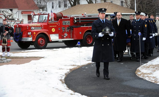 11 jan 2011 tues  
 Funeral procession for Framingham firefighter Mike Urban, 57.
Framingham firefighter Tim Campion carries Urban's helmet as the casket is carried into St. Stephen's Church.