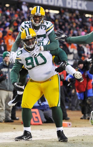 Green Bay Packers defensive tackle B.J. Raji (90) celebrates with teammate Sam Shields (37) after Raji's interception and runback for a touchdown during the second half of the NFC Championship NFL football game Sunday, Jan. 23, 2011, in Chicago. (AP Photo/Jim Prisching)