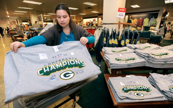 Pam Kauth, an employee of the Boston Store located inside Regency Mall in Racine, Wis., puts out new Green Bay Packer NFC Champion short-sleeve t-shirts on display on Monday, Jan. 24, 2011. The T-shirts, which sell for $20 each, are one of many expected Packers-themed merchandise expected to arrive at the store this week.