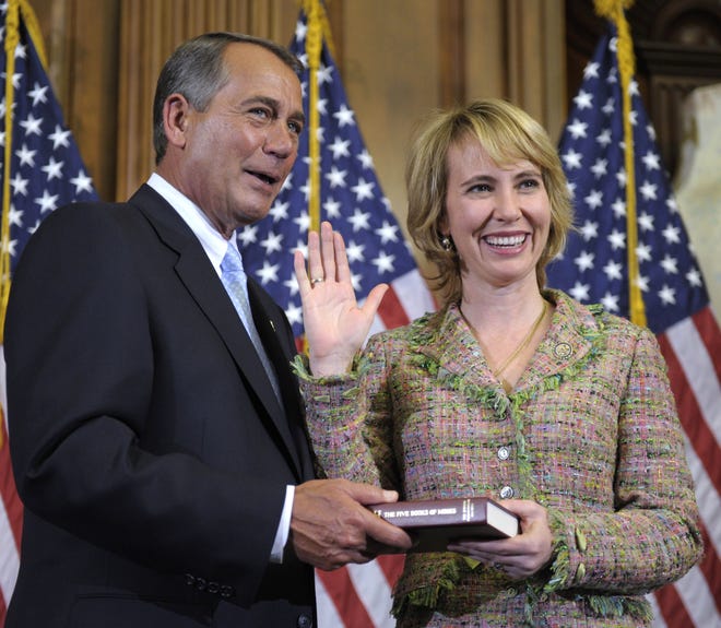 In this Jan. 5, 2011 file photo, House Speaker John Boehner reenacts the swearing in of Rep. Gabrielle Giffords, D-Ariz., on Capitol Hill in Washington. Congressional officials say Giffords has been shot in her district.