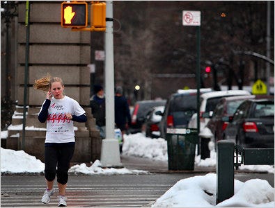 New York State is considering a ban on the use of electronic devices while crossing streets. Above, a jogger in New York City.