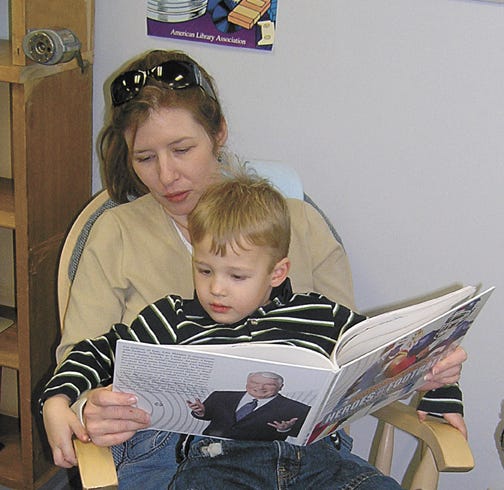 Sitting, rocking and reading in the children’s section of the Pontiac Public Library are Jack Jacobson, 3, and his mommy, Karen Jacobson of Pontiac. They were reading “Heroes of Football” by John Madden. The rocking chair was donated to the library as a memorial.