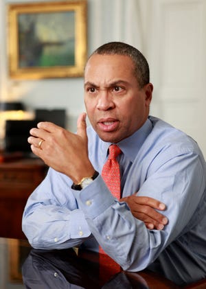 Gov. Deval Patrick speaks with reporters at the State House in Boston.