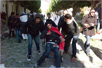A young man injured during clashes between protesters and the Tunisian police was carried away in a wheelchair near the office of the prime minister in central Tunis.
