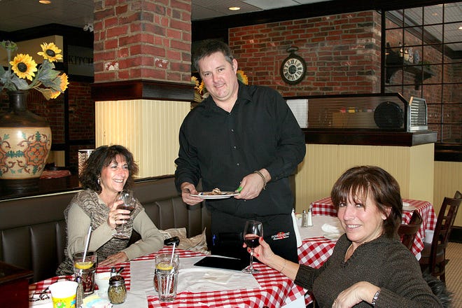 Server Howie Smith serves Linda, left, and MaryJo, who are celebrating Linda's birthday, tiramisu to wrap up their birthday meal.