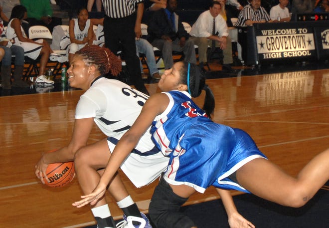 Westside's Azia Gibson (right) crashes into Grovetown's Ebony Wells as they battle for the ball. Wells recorded a triple-double with 22 points, 16 rebounds and 14 blocks as the Warriors rolled.