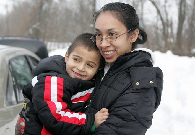 Marisa Pina holds her son, Joel Villarruel, 3, as she talks about the proposed half-day kindergarten program Friday, Jan. 28, 2011, outside Dennis Early Education Center in Rockford where her son attends school.