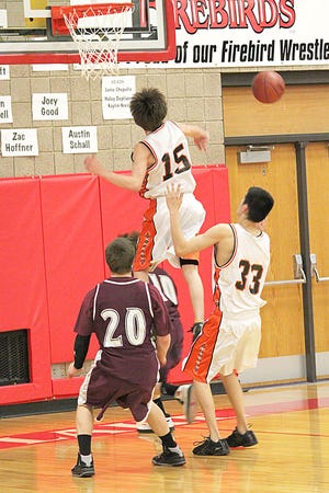 Warwick’s Melvin Langstaff (15) gets high off the ground to reject a shot by Rolette-Wolford’s Chris Julson (10) during Saturday’s Class B Day at the Devils Lake Sports Center.