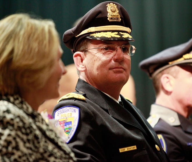New Stougton police chief Paul Shastany sits on stage at Stoughton High School with his wife Ann Marie.