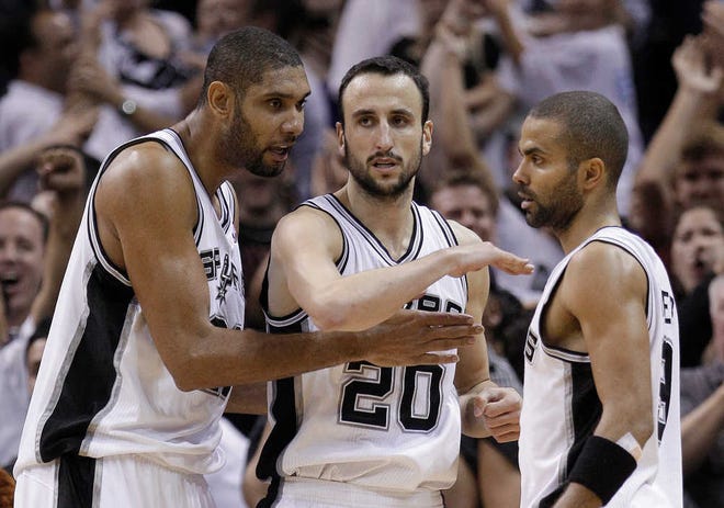 FILE - In this Nov. 22, 2010, file photo, San Antonio Spurs' Tim Duncan, left, and Tony Parker, of France, right, congratulate Manu Ginobili, of Argentina, after Ginobili was fouled as he scored late in an NBA basketball game against the Orlando Magic in San Antonio. Ginobili is the Spurs' best candidate for selection by coaches to the All-Star team, averaging 18.8 points. Parker is next at 17.5 on 52 percent shooting, while Duncan's average of 13.6 points is third on the team and only 20th best among West forwards. (AP Photo/Eric Gay, File)