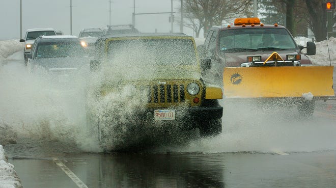Traffic negotiates large puddles and street flooding on Quincy Shore Drive in Quincy, caused by melting snow and rain on Feb. 2, 2011.