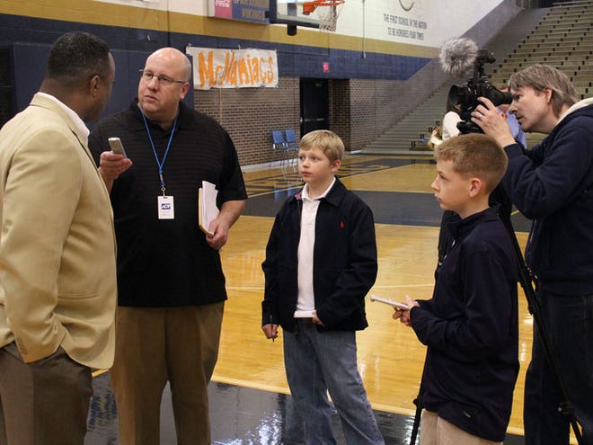 Landrum Middle School students Ross Rothell, center, and Blaine Johnson, right, look on as Herald-Journal sports writer Eric Boynton interviews Spartanburg football coach Freddie Brown on Wednesday. The students were participating in National Groundhog Job Shadow Day.