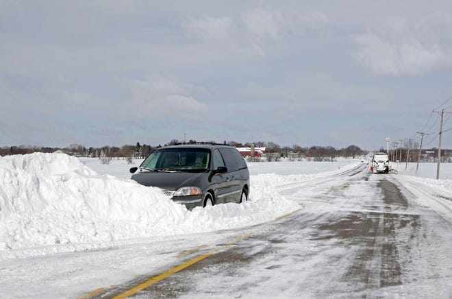 An abandoned car sits on the side of the road as a snow plow clears South Perryville Road Wednesday, Feb. 2, 2011, in Cherry Valley.