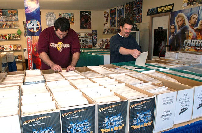 Comics as far as the eye can see: Curt Griffin (right), owner of Heroic Adventures in Perry Township, looks through comics with long-time customer, Patrick St. Pierre of Kent.