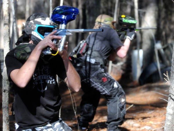 James Kowalski (left) and Thomas Banks loos to shoot during a game at Adrenaline Junkie Paintball in Leland on Saturday, Jan. 29, 2011.