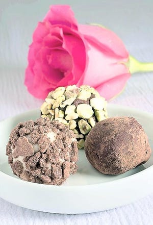 From left: White chocolate-sour cream cookie truffle, a honey-pistachio truffle and a strawberry-mint truffle. These truffles can be made several days in advance. If made ahead, truffles coated in cocoa powder may need to be rerolled in additional powder just before serving. (AP Photo/Larry Crowe)