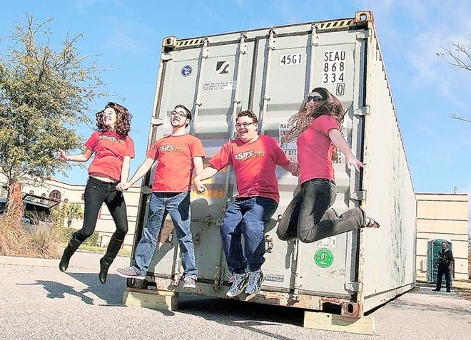 Flagler College students Emily Marcellus, Spencer Larr, Randol Hentges and Beth Houston jump in front of a shipping container for a video camera in the parking lot of The St. Augustine Record on Wednesday. The students are part of a group that will convert the container into living space. By PETER WILLOTT, peter.willott@staugustine.com
