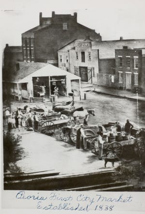 A copy of a daguerreotype called "Market at Foot of Hamilton and Washington" dated 1854 is credited to be the "first out of doors" photograph taken in Peoria.