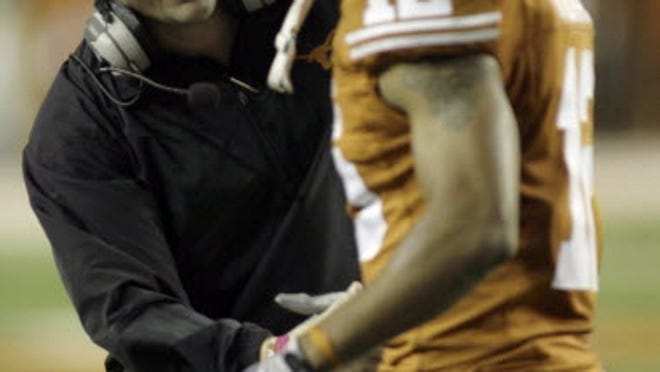 Texas defensive coordinator Will Muschamp, left, congratulates safety Earl Thomas shortly after he grabbed a Colorado pass and returned it 92 yards for a touchdown during the third quarter of their NCAA college football game Saturday, Oct. 10, 2009, in Austin, Texas. Texas won 38-14.