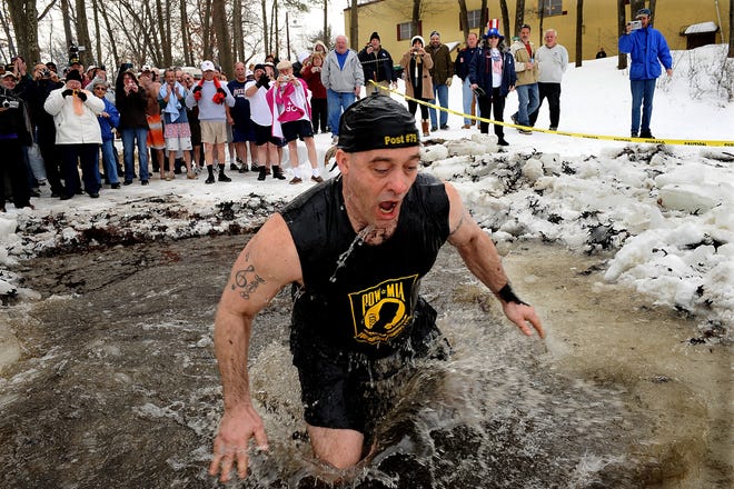 Robert O'Connell of Natick, the chaplain for Natick Amvets Post 79, comes out of Lake Cochituate very cold after participating in the Passion Plunge Saturday.