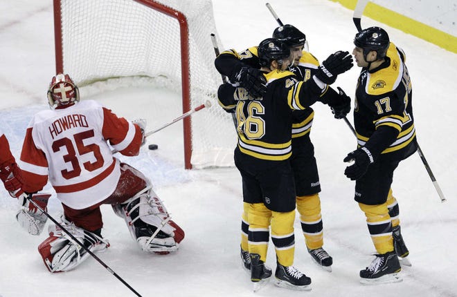 The Bruins’ David Krejci (46) is congratulated by teammates Patrice Bergeron and Milan Lucic (17) after scoring past Red Wings goalie Jimmy Howard during the first period.