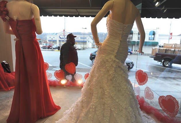 A man walks past the windows of Mary's Bride and Formal on 7th Avenue in Beaver Falls Monday afternoon. Their window was all decked out for Valentine's Day with paper hearts on the windows and manequins dressed in red and white. Workers there said they change the window display every Tuesday.
