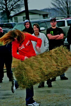 FFA students participate in the Hay Bale Toss event at West Central High School Tuesday night as part of the annual FFA Olympics.