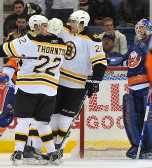 Shawn Thornton (22) and Blake Wheeler (26) congratulate Tyler Seguin (left) on his goal as Islanders goalie Al Montoya reacts during the second period of last night's Bruins win.