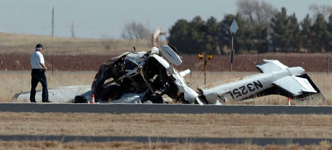 Investigators work the scene Friday where a single-engine Cessna aircraft crashed near the Levelland Airport. Two people were killed in the crash and two were injured.