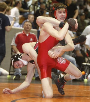 n Northwest’s Brandon Wilhelm (in red) works to shake Norton’s Josh Beddow off his back during their 119-pound match at the Division II sectional at Hoover High School.