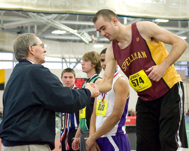 Cardinal Spellman's Justin Powell is congratulated by Dick Baker, assistant director of MIAA, after receiving his medal for second place in the high jump at the Div. 4 Championship Track & Field Championships on Sunday at the Reggie Lewis Center in Boston.