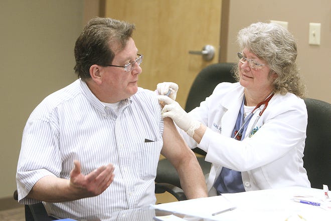 INDEPENDENT KEVIN WHITLOCKn Nicki Russell, an RN with the Aultman Hospital Wellness on Wheels program gives a free flu shot to Denny Sarbak of Massillon at the Massillon Salvation Army.