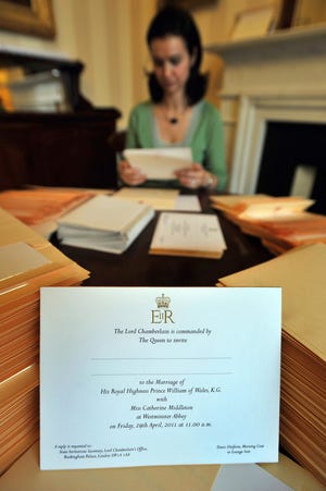 In this photo taken Wednesday, Feb. 16, 2011 at Buckingham Palace in London, a member of the Lord Chamberlain's Office, no name given, places invitations into envelopes, to the wedding of Prince William and Kate Middleton, before posting them to the lucky guests who will be present at the April 29, 2011 royal wedding to be held in Westminster Abbey. (AP Photo/PA, John Stillwell)
