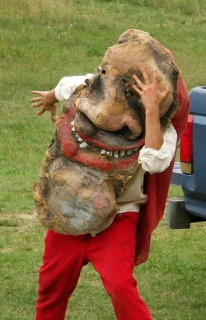 A puppeteer is pictured in a Kasper mask.