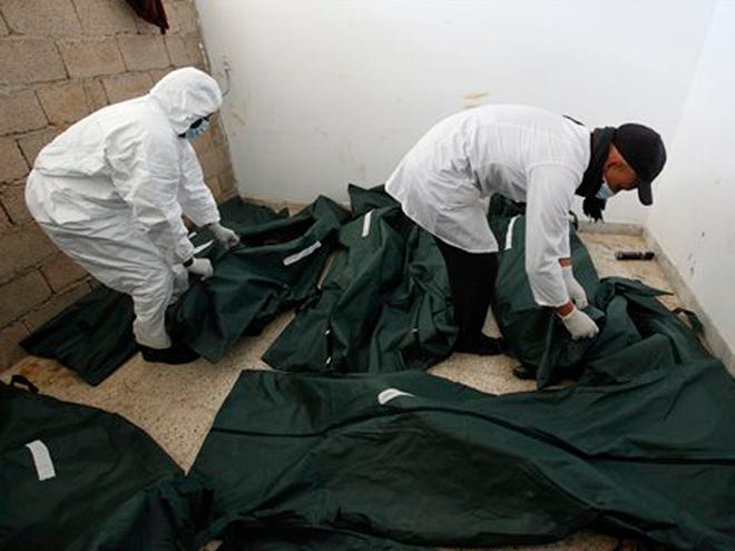 Libyan mortuary assistants look to unidentified dead burned bodies who were killed last week during the demonstration against Libyan leader Moammar Gadhafi at a morgue hospital Thursday in Benghazi, Libya.