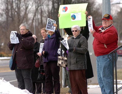 Members of the progressive advocacy group Move On protest outside Congressman Jon Runyan's office Thursday in Mount Laurel. The area residents were protesting Runyan's proposal to slash more than $60 billion from this year's federal budget.