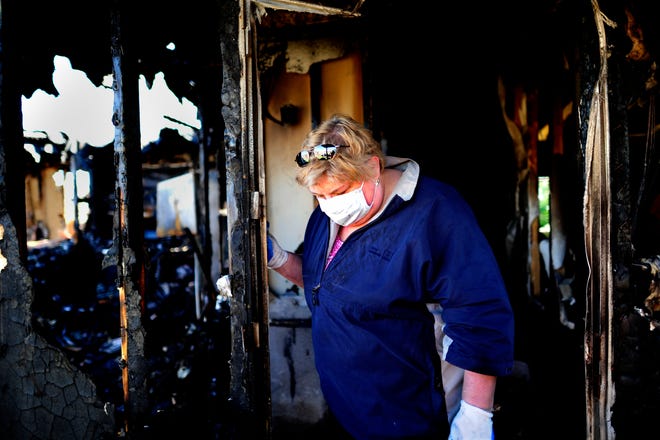 Michele Hattman looks for salvageable items in what is left of her Hephzibah home after a fire destroyed it early Tuesday.