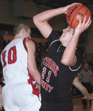 Stark County’s Ethan Ely (21) shoots around Orion defender Danny DeBacker during Friday night’s Galva Regional title game.
