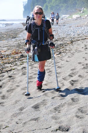 Sarah Doherty with with sand-shoes on the West Coast Trail walking on a beach.
