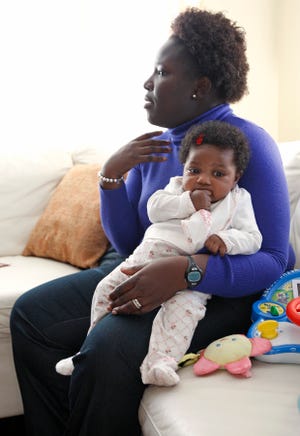 Shirley Robert, 27, and her daughter Amelie, 6 months, in their home in Randolph.
