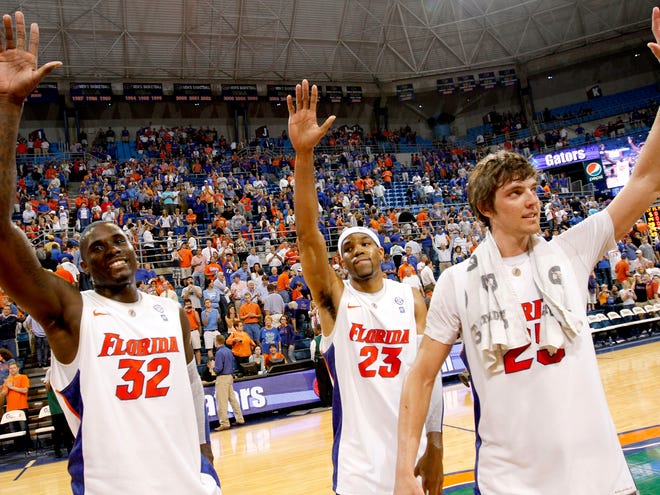 Florida seniors Vernon Macklin, left, Alex Tyus and Chandler Parsons, right, wave to the crowd after their final home game, a win against Alabama, at the O'Connell Center on Tuesday.