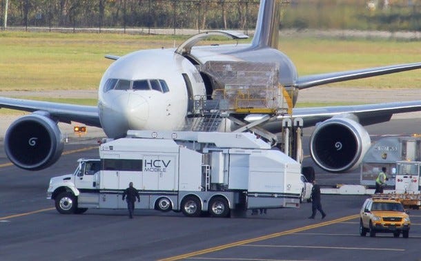 A mobile x-ray truck sits near a grounded UPS cargo jet as the plane is searched by law enforcement officials at Philadelphia International Airport in Philadelphia, Pennsylvania, October 29, 2010. Two suspicious packages being flown from Yemen to the United States were found in Britain and Dubai on Friday after a tip prompted authorities to search cargo planes on both sides of the Atlantic. The packages spurred searches and investigations of jets arriving at New York's JFK Airport, Newark International Airport in New Jersey and the airport in Philadelphia. Authorities are investigating reports the parcels were bound for a synagogue and Jewish community center in Chicago. REUTERS/Tim Shaffer (UNITED STATES - Tags: TRANSPORT POLITICS CRIME LAW)