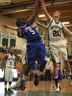 Duxbury's Curtis Owen battles for the rebound with Quincy's Reggie Cesar during their Division 2 South tournament game on Tuesday, March 1, 2011. Duxbury won, 52-47.