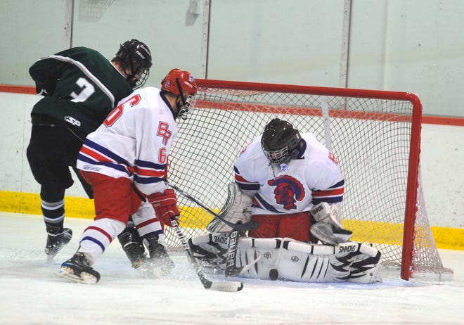 Bridgewater-Raynham goalie Craig Pantano drops to his knees to make a save as Bridgewater-Raynham's Chris Oien battles with Duxbury's Tim Harrison for the rebound during Wednesday's Division I South first round playoff game at Gallo Ice Arena in Bourne.